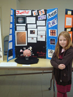 Female student stands in front of her science exhibit