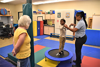 A Salt Point Center student uses a trampoline in the physical therapy room.