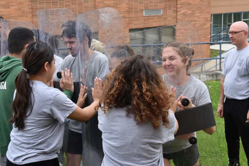 Security and Law students practice holding off students acting as rioters using protective shields.
