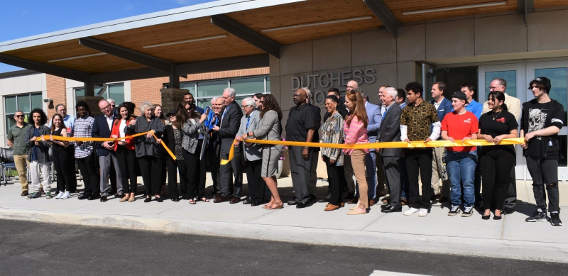 Dutchess BOCES staff cut the ribbon on the new building as staff and dignitaries look on.