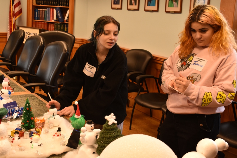 Resilience Academy students Samantha Werner and Jasmine Gibson-Bocus judge Administration staff’s snowmen creations.