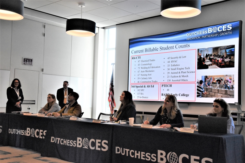 District Superintendent Dr. Jodi DeLucia and Assistant Superintendent for Business and Operations Mike Skerritt talk about the increase in students the agency has seen standing in front of a slide showing current student counts.