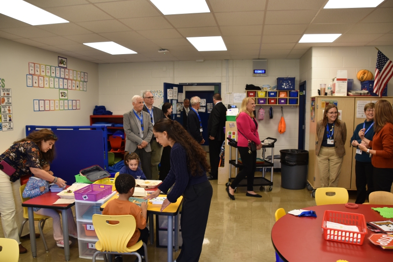 Board members visit a classroom at Salt Point Center as children eat lunch.