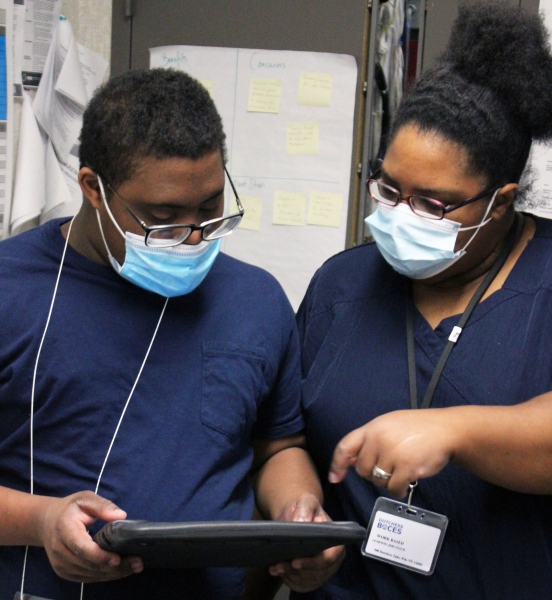 Student Malcolm Lewis and BOCES job coach Fabienne Simons discuss the day's work