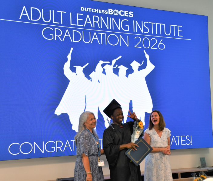 A student gives the victory sign after receiving his certificate.