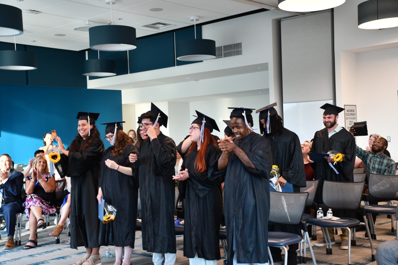 Students in the Adult Learning Institute's GED program move the tassels on their graduation caps following the ceremony.