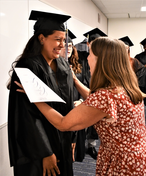 GED graduate Natalia Meza smiles nervously as Teacher Dianne Ham tells her not to be nervous just before students entered the ceremony.
