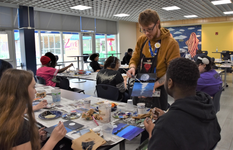 Resilience Academy Teacher Michael Hollick conducts a paint and sip event with students in recognition of their good behavior.