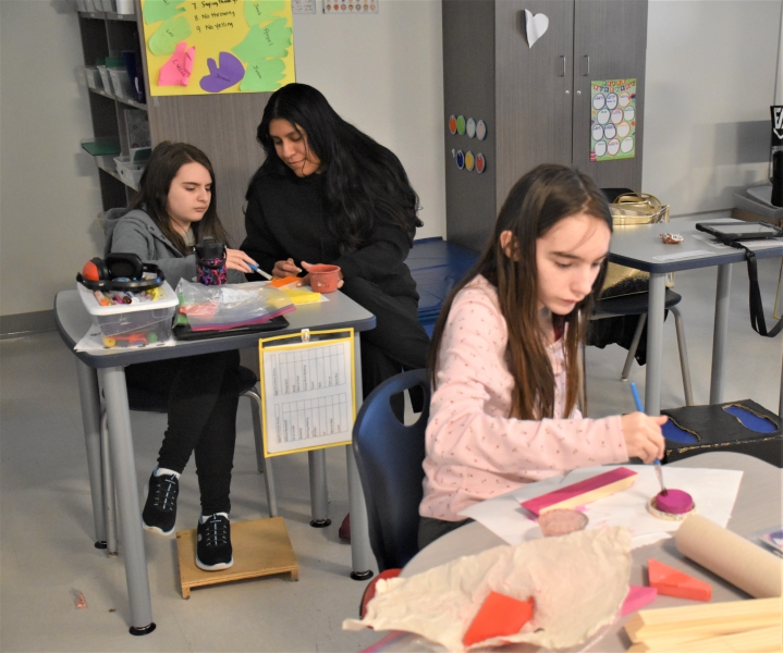 Students paint blocks being used in a puzzle as part of an industrial arts project at Resilience Academy.