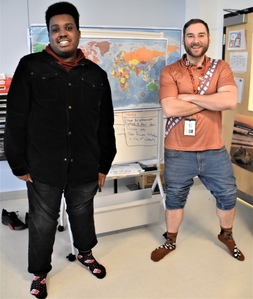 Resilience Academy Teacher Jeff Scalzo and student Joe sport crazy socks for World Down Syndrome Day. Joe is wearing Pepsi socks while Scalzo has Chewbacca.