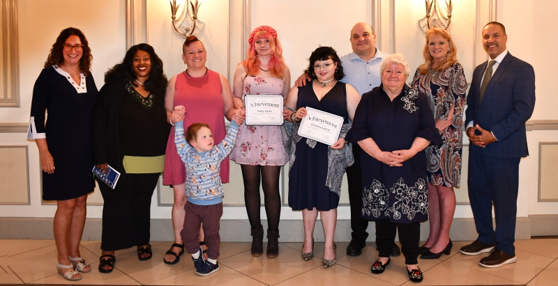 Resilience Academy Distinguished Graduates Avery Jones and Christina Leone pose for a photo with their families and Dutchess BOCES administrators after receiving their certificates.