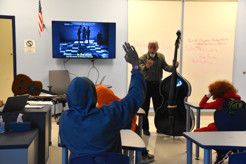 Music Teacher Dean Karahalis shows a bass to students as part of a Hispanic Heritage month lesson.