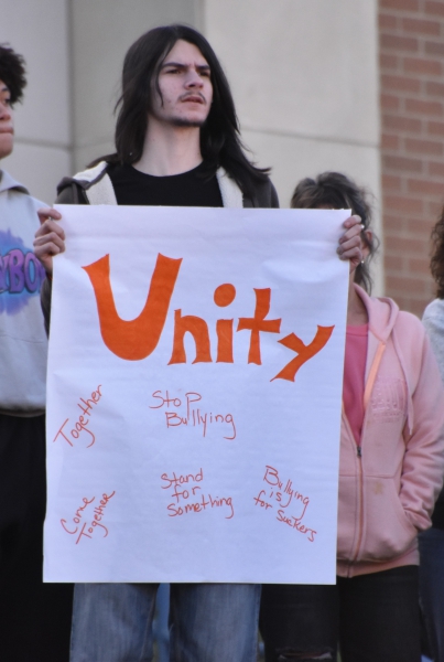 A student holds a Unity sign with anti-bullying messages.