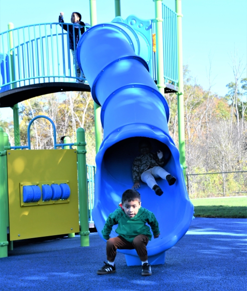 Students slide down one of the new slides on the playground at Salt Point Center