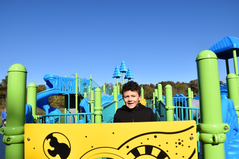 Cameron Hartman, who provided input on the new playground, stands atop one of the structures.