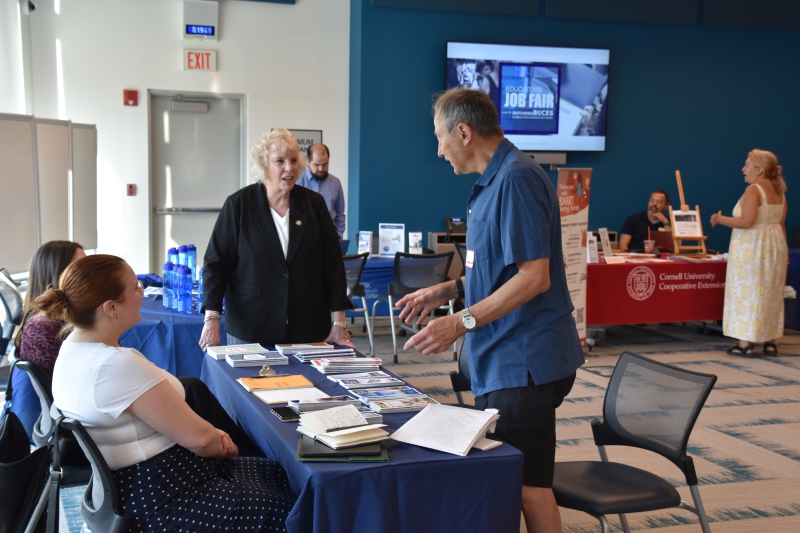 Assemblymember Didi Barrett speaks to one of the attendees about concerns they have.