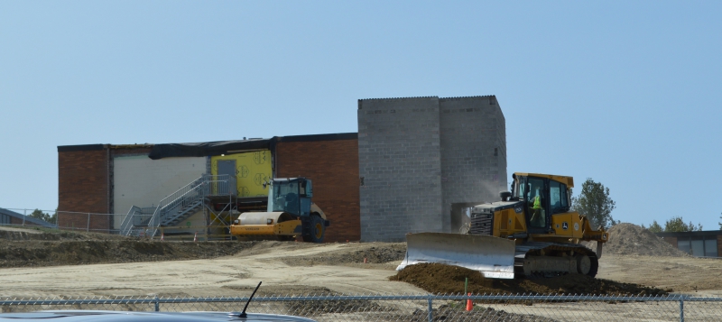 [PIC] A bulldozer moves dirt in preparation for the new building’s foundation.