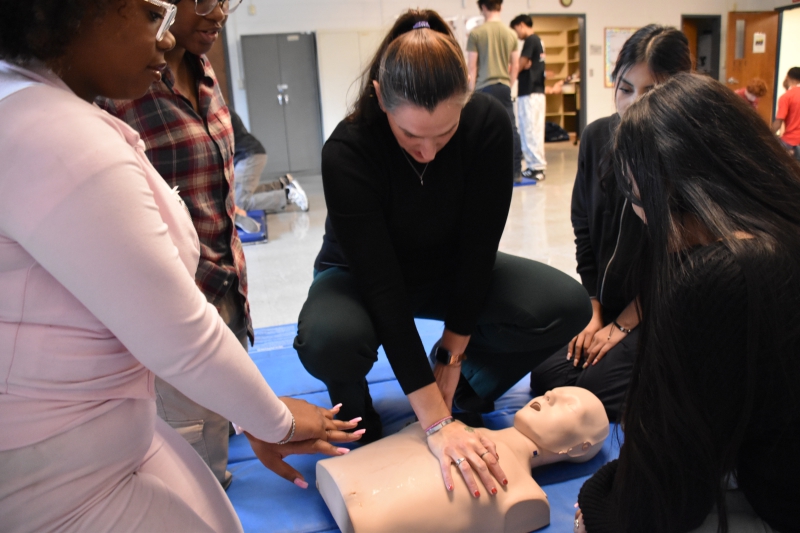 EMT Teacher Danielle Bohlmann demonstrates how to perform CPR chest compressions for EMT and Security and Law students.
