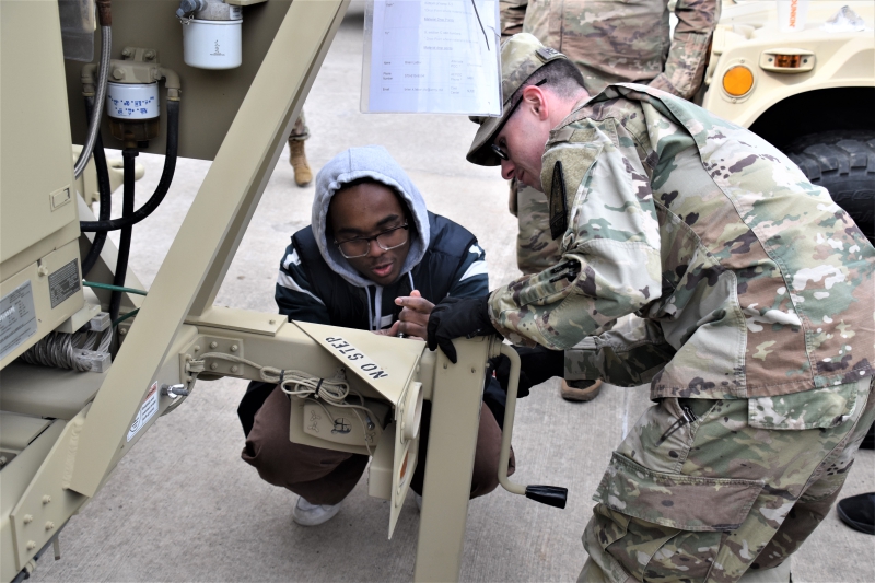 A CTI student helps a member of the National Guard set up the Satellite Transportable Terminal at Camp Smith during a field trip in March 2026