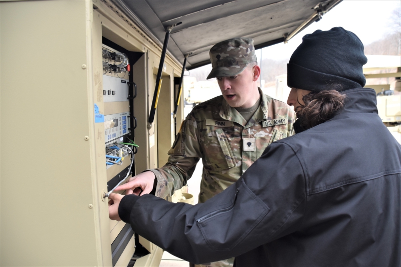 A National Guard member explains some of the connections and controls to a student in the Career and Technical Institute's Computer Hardware, Networking and Cybersecurity program.