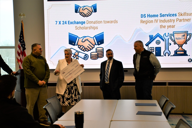 Work-Based Learning Coordinator Sharon Myers and Director of CTE and Adult Education Nicholas Millas (center) accept a $10,000 donation check from Dan Moore and Joe Szabo, representing nonprofit 7x24 Exchange