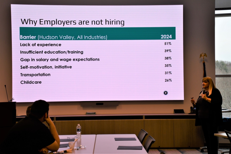 Dutchess County Workforce Investment Board Executive Director Louise McLoughlin speaks to the Main Advisory Committee on Thursday, March 19, 2026. A slide on the screen shows several reasons Dutchess employers noted for not hiring people in 2024.