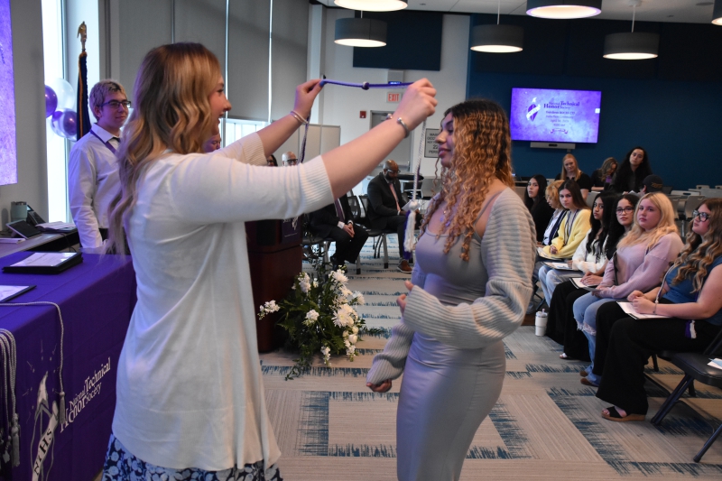 Isabella Hughes, a Careers in Animal and Plant Sciences student at the Career and Technical Institute, receives her National Technical Honor Society cord from NTHS Vice President Natalie Schultz.