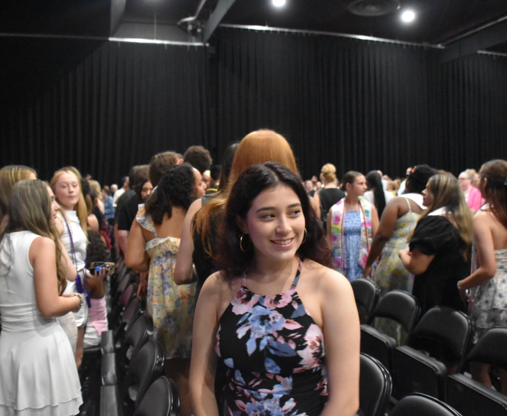 A student smiles as she awaits the start of the ceremony