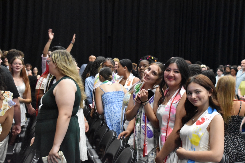 Students share a moment before the ceremony begins.