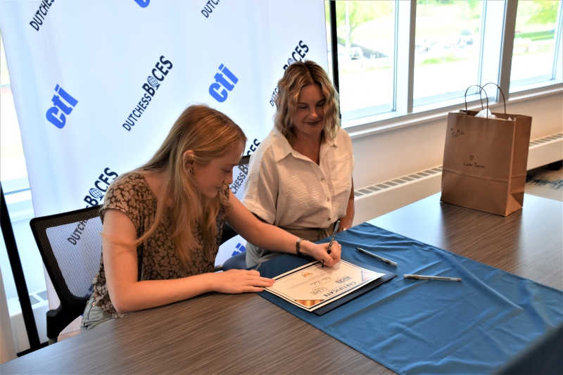 Julia Tarkos of Hyde Park, who will complete the Cosmetology program, signs on with Luxe Salon and Spa