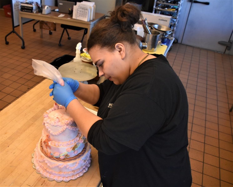 Ballery Vargas practices writing on a cake for the SkillsUSA States Competition