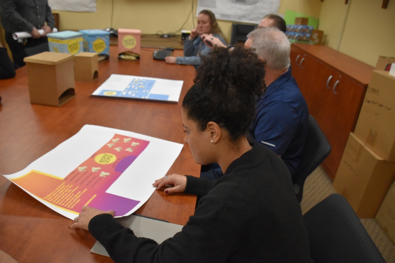 Viking Packaging's Operational Excellence Manager Evelyn Autera looks over a student-created design.