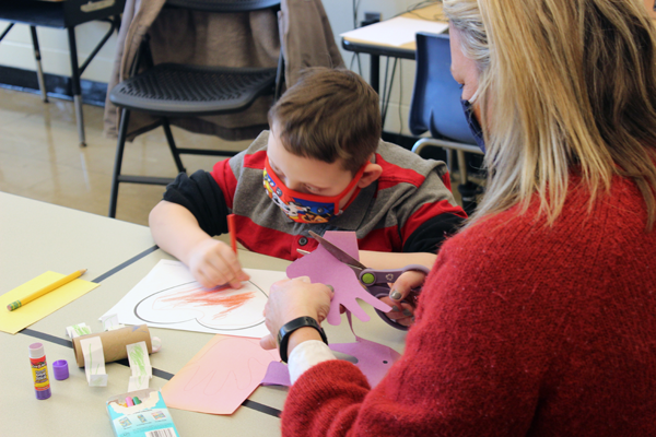 [PIC] Salt Point Center Teaching Assistant Kelsey Butkiewicz helps her students with coloring hearts 