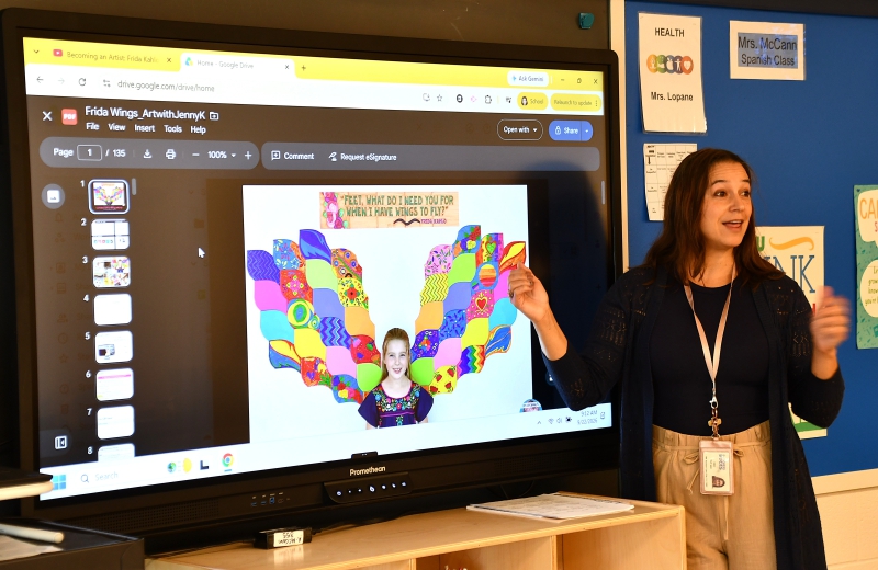 Spanish Teacher Amy McCann speaks to the class about Mexican artist Frida Kahlo and shows the complete mural students are each making a piece of