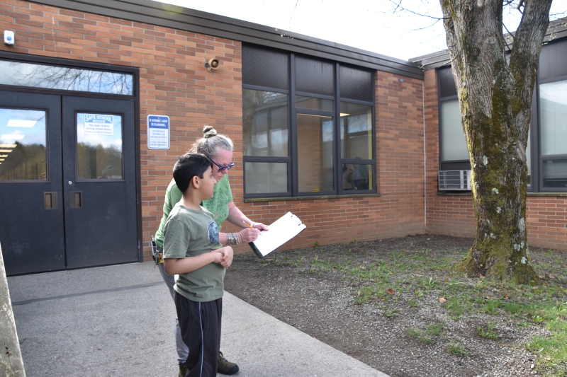 A student examines a tree as part of the nature walk outside of SPC.