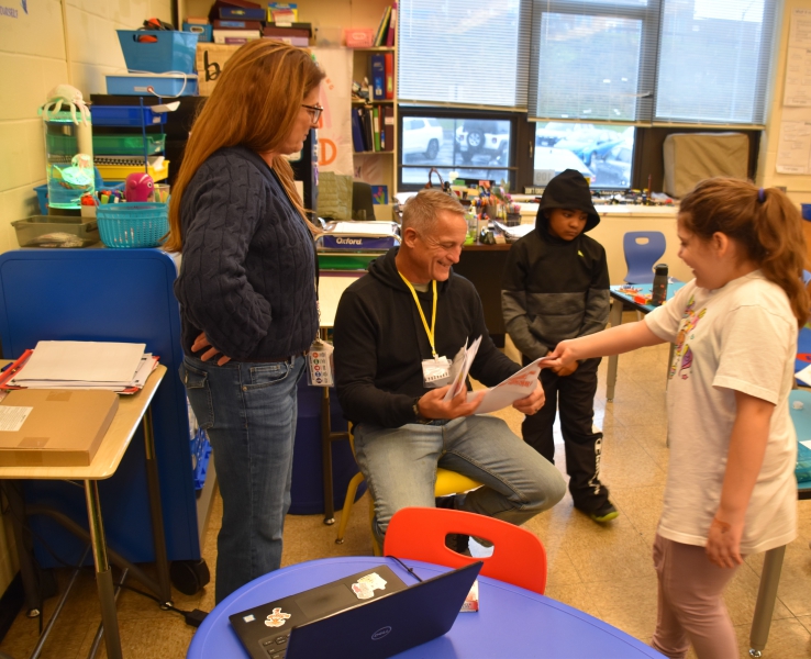 A student in Christine Ciccone's class hands a card to U.S. Army veteran Jaimie Browne.